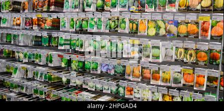 Moskau, Russland, Dezember 2019: Nahaufnahme eines Stands mit Papiertüten mit Gemüsesamen: Kürbisse, Kohlköpfe. Verkauf im Laden. Stockfoto