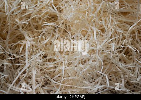 Dünne wirbelnde Holzspäne, Sägemehl zum Abfüllen von Paketen, alte Spielzeuge füllen. Bio-umweltfreundliches Material. Abstrakter Hintergrund. Stockfoto