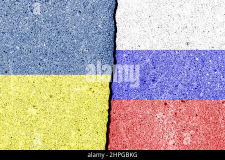 Der Riss zwischen der Russischen Föderation und ukrainischen Fahnen an der Betonmauer. Das Konzept der Sanktionen, Krieg, die Verschlechterung der diplomatischen Beziehungen Stockfoto