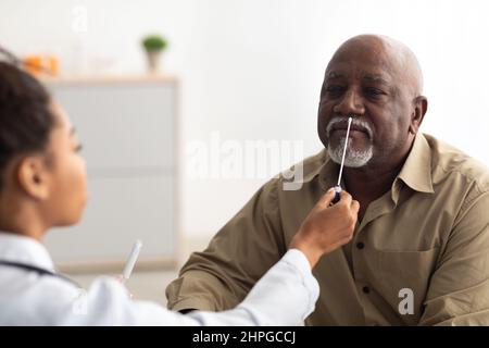 Arzt, der PCR-Testprobe von potenziell infizierten erwachsenen Mann nimmt Stockfoto