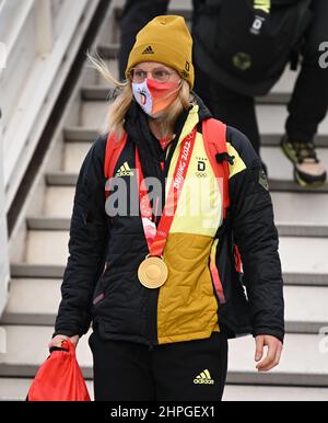 21. Februar 2022, Hessen, Frankfurt/Main: Die Langlauffahrerin Victoria Carl kommt am Frankfurter Flughafen mit ihrer Goldmedaille um den Hals aus dem Flugzeug, als die deutsche Mannschaft von den Olympischen Spielen in Peking zurückkehrt. Foto: Arne Dedert/dpa Stockfoto