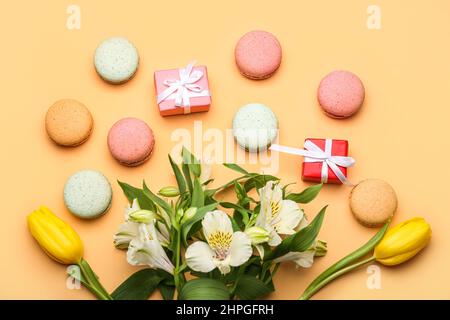 Komposition mit schönen Blumen, Geschenken und süßen Makronen auf farbigem Hintergrund. Feier zum Internationalen Frauentag Stockfoto