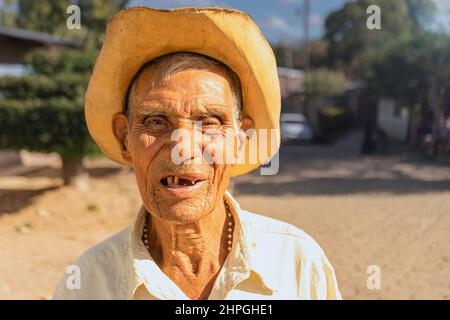 Lateinischer alter Mann ohne Zähne und mit Hut lächelnd und mit Blick auf die Kamera Stockfoto