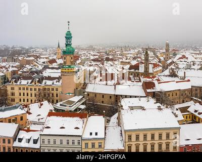 Luftaufnahme über den ikonischen Feuerturm und das Rathaus von Sopron im Herzen der Stadt. Der ungarische Name ist Tűztorony. Winterliche Stadtlandschaft verschneite Dächer. Stockfoto