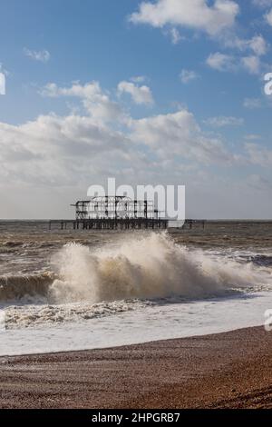 Stürzende Wellen am Brighton Beach, hinter dem West Pier Stockfoto