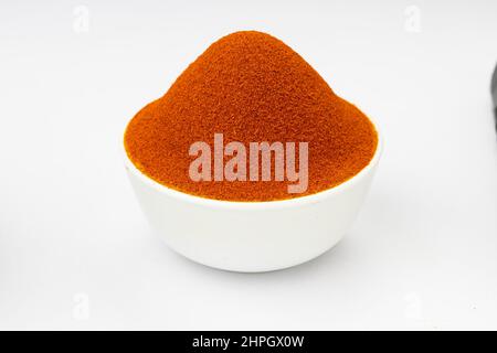 Rotes, kühles Pulver, indische Gewürze, in einer weißen Schale mit weißer Textur oder Hintergrund angeordnet Stockfoto