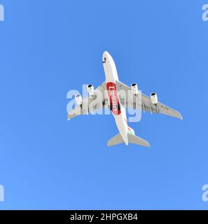 INGLEWOOD, KALIFORNIEN - 12. FEB 2022: Ein Emirates Jet Airliner fliegt über dem Himmel gegen einen blauen Himmel. Stockfoto