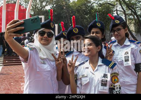 Dhaka, Bangladesch. 21st. Februar 2022. Eine Gruppe Freiwilliger des BNCC (Bangladesh National Cadet Corps) posieren für ein Selfie im Martyrs Monument, oder Shaheed Minar während des Internationalen Muttersprachentages in Dhaka. Oder Shaheed Minar, am Internationalen Tag der Muttersprache in Dhaka, wird der Internationale Tag der Muttersprache zum Gedenken an die Bewegung begangen, in der 1952 eine Reihe von Studenten starben, die die Anerkennung von Bangladesh als Staatssprache des ehemaligen Ostpakistans, heute Bangladesh, verteidigten. Kredit: SOPA Images Limited/Alamy Live Nachrichten Stockfoto