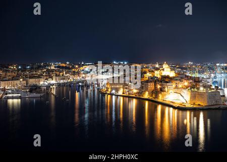 Blick auf drei Städte in Malta bei Nacht. Foto aus Valletta. Der Grand Harbour erleuchtet bei Nacht. Stockfoto