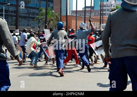 Polizeibeamte mit Schlagstöcken greifen oppositionelle MDC-Mitglieder im zentralen Geschäftsviertel Harare an. Die Oppositionsmitglieder hatten einen friedlichen marsch durchgeführt, als die Polizei begann, sie zu überfahren. Simbabwe. Stockfoto