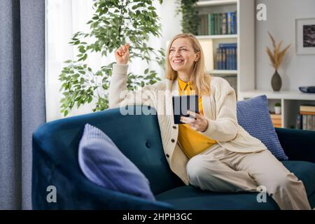 Frau mit Tablet auf couch Stockfoto