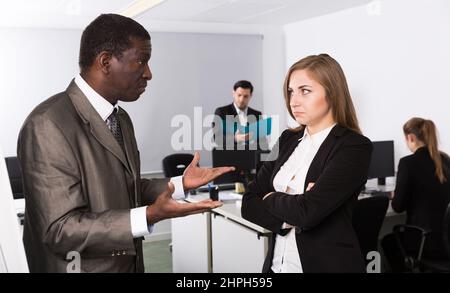 Unglückliche Frau Manager hören wütenden Mann Chef pointinting zu vermisst in Arbeit Stockfoto