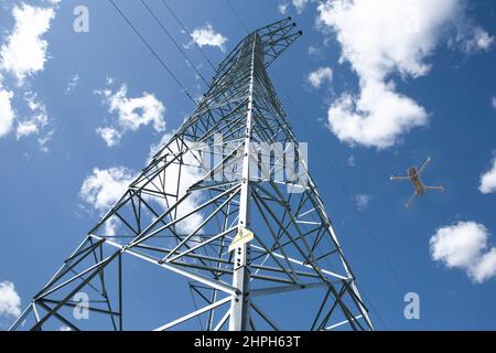 Dron fliegt über den Stahlmast. Drohnen für das Inspektionskonzept der Stromleitung Stockfoto