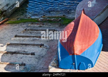 Blaues Boot, das kopfüber in einem kleinen Hafen auf der Insel Malta liegt. Stockfoto