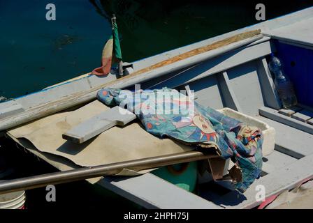 Kleines blaues Fischerboot mit Ausrüstung und italienischer Flagge. Stockfoto