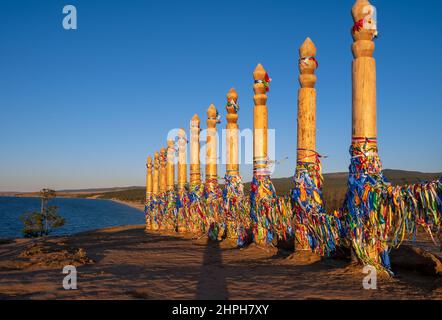 Bunte Bänder auf den Holzsäulen in der heiligen burjat Platz auf Kap Burkhan in Khuzhir Dorf in Olchon Insel, Baikalsee, Russland Stockfoto