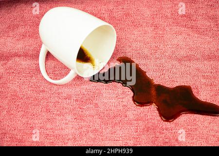 Kaffeefleck auf hellem Stoff, Tischdecke, Sofa. Waschen, Reinigung des Stoffes. Hochwertige Stoffe. Wasserabweisende Imprägnierung. Stockfoto