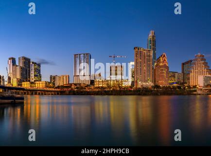 Die Hochhäuser der Innenstadt spiegeln den goldenen Sonnenuntergang über dem Lady Bird Lake oder dem Town Lake am Colorado River in Austin, Texas, USA wider Stockfoto