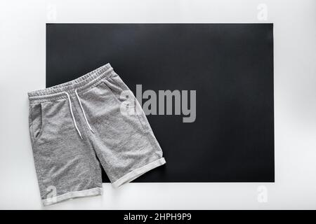 Graue Shorts Hose für den Männersport. Basic Freizeitkleidung Sport grauen männlichen Shorts auf weißem schwarzen Rahmen Hintergrund mit Kopie Platz. Minimalistisches Basic Stockfoto