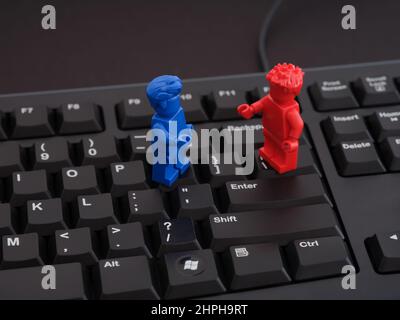 Tambow, Russische Föderation - 13. August 2021 Eine blaue Lego-Minifigur und eine rote Lego-Minifigur stehen auf einer schwarzen Tastatur. Nahaufnahme. Stockfoto