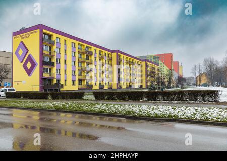 Zawiercie, Polen - 2021. April: Bunte Fassade eines Wohnblocks bei verschneiten Tagen Stockfoto