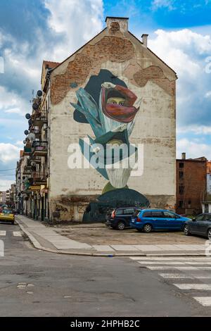 Legnica, Polen - April 2021: Fassade eines alten Mietshauses mit gemaltem Wandgemälde an der Seite Stockfoto