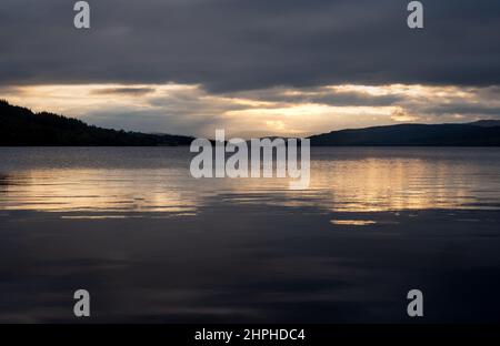 Ein Blick auf die Länge des Loch Rannoch vom Ostufer bei Sonnenuntergang in Richtung Stob na Cruaiche, Rannoch, Schottland, Vereinigtes Königreich Stockfoto