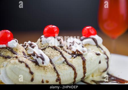 Nahaufnahme von köstlichem Bananensplitterdessert und Himbeer-Bierglas Stockfoto