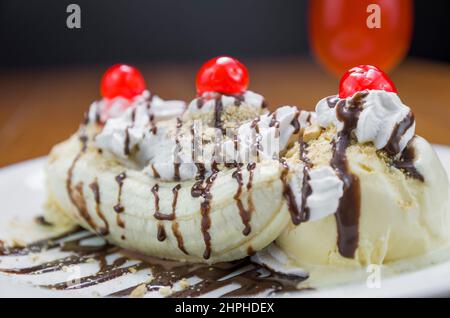 Nahaufnahme von köstlichem Bananensplitterdessert und Himbeer-Bierglas Stockfoto