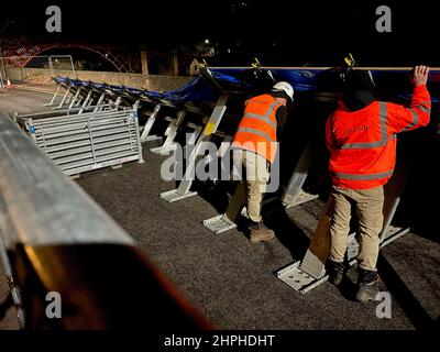 Arbeiter bauen am Fluss Severn in Ironbridge, Shropshire, Hochwasserschutzmaßnahmen auf, nachdem sie eine seltene „beharrliche“ Warnung über Wharfage, Ironbridge und Wribbenhall, Bewdley, erhalten hatten, wo steigende Wasserstände ein „erhebliches Risiko für das Leben“ darstellen, wobei einige Bewohner gebeten wurden, ihre Häuser zu evakuieren. Der Sturm Franklin ist in ganz Großbritannien umgezogen, nur wenige Tage nachdem der Sturm Eunice Gebäude zerstört und 1,4 Millionen Häuser ohne Strom gelassen hat. Bilddatum: Montag, 21. Februar 2022. Stockfoto