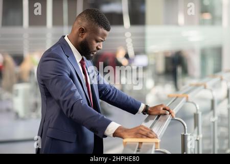 Verärgerte afroamerikanische Unternehmer, die durch Geländer stehen Stockfoto