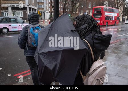 Eine Frau kämpft an einem stürmischen Tag in London, Großbritannien, mit Regenschirm Stockfoto