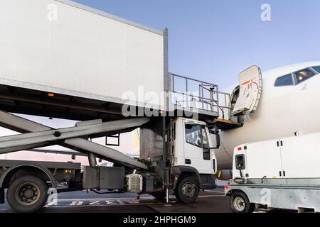 Nahaufnahme Detailansicht von Hochlader Cargo Catering Service LKW Verladen von kommerziellen Passagier aicraft mit Lebensmittel-Sets und Paketversand. Flughafenflugzeug Stockfoto