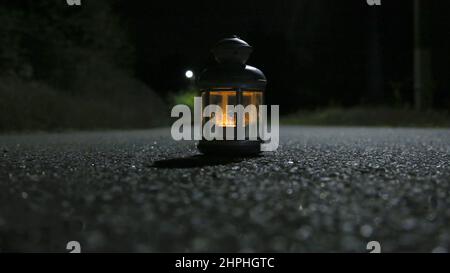 Eine brennende Laterne im Dunkeln, die die Nachtstraße beleuchtet Stockfoto