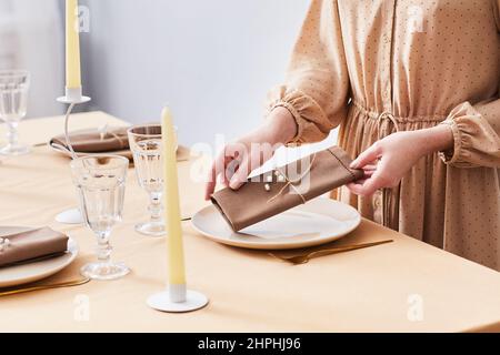 Nahaufnahme einer jungen Frau, die den Esstisch in weichen Frühlingstönen schmückt, Platz kopieren Stockfoto