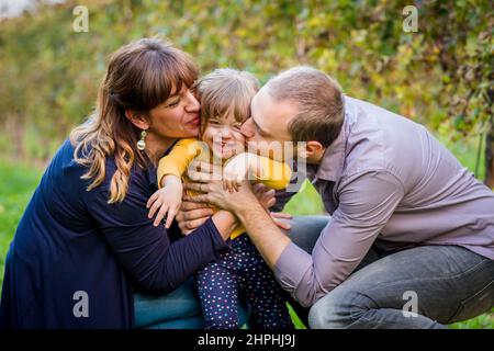 Porträt einer glücklichen Familie, die an sonnigen Tagen gemeinsam auf einem Weinberg Spaß hat Stockfoto