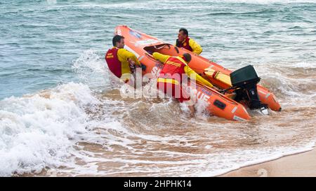 Sydney, New South Wales Australien - 26 2021. Dezember: Die Rettungsschwimmer des Mona-Wale-Strandes starten ihr Boot vom Strand aus und durch die Brandung Stockfoto