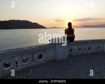 Santos, Sao Paulo, Brasilien. 21st. Februar 2022. (INT) die Badegäster genießen den Sonnenuntergang in Ponta da Praia in Santos. 21. Februar 2022, Santos, Sao Paulo, Brasilien: Badegäste genießen den Sonnenuntergang am Ponta da Praia, in Santos, an der Südküste von Sao Paulo, am Montag (21), dem Beginn der Karnevalswoche. (Bild: © Luigi Bongiovanni/TheNEWS2 via ZUMA Press Wire) Stockfoto