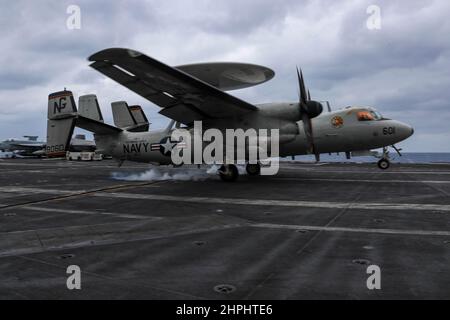 PHILIPPINISCHES MEER (Feb 21, 2022) eine E-2D Hawkeye, die den "Wallbangern" des Carrier Airborne Early Warning Squadron (VAW) 117 zugewiesen wurde, landet auf dem Flugdeck des Flugzeugträgers USS Abraham Lincoln (CVN 72) der Nimitz-Klasse verhaftet. Die Abraham Lincoln Strike Group befindet sich im geplanten Einsatzgebiet der US-Flotte für 7th, um die Interoperabilität durch Allianzen und Partnerschaften zu verbessern und gleichzeitig als reaktionsfähige Truppe zur Unterstützung einer freien und offenen Region im Indo-Pazifik-Raum zu dienen. (USA Navy Foto von Mass Communication Specialist 3rd Class Javier Reyes) Stockfoto