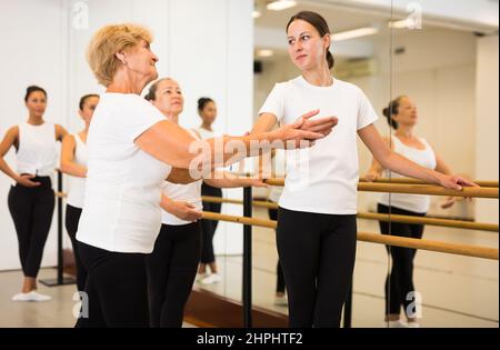 Frauen trainieren Ballettbewegungen mit Trainer Stockfoto