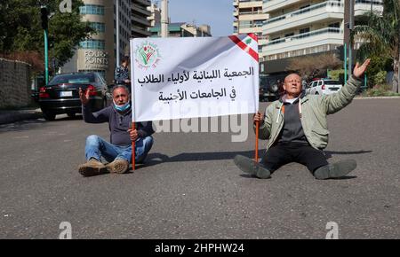 Ahmed, der Mann auf der rechten Seite, protestiert, weil er seinem Sohn Ali, der an der ukrainischen Universität Kharkiv in Beirut, Libanon, Medizin studiert, kein Geld schicken darf, 21. Februar 2022. Er und andere Eltern libanesischer Studenten in der Ukraine stehen vor dem UNESCO-Palast, wo das libanesische Parlament eine Plenarsitzung abhielt. Unterstützt von der libanesischen Vereinigung für Eltern von Studenten an ausländischen Universitäten, verurteilen Familien von Studenten in der Ukraine, besorgt über den ankommenden Krieg, die verzögerte Anwendung des "Studenten-Dollar-Gesetzes", das ihnen Transfers von bis zu 10.000 US-Dollar zu einem niedrigeren Wert ermöglichen sollte Stockfoto