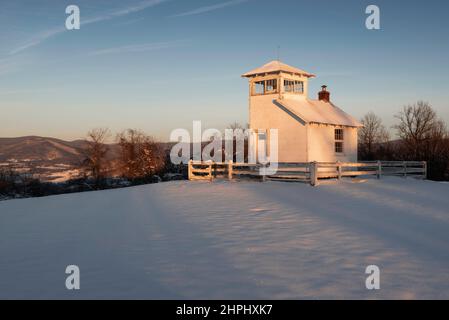 Die aufgehende Sonne erhellt an einem kalten Wintermorgen einen historischen Feuerauswachturm und die östlichen Bergrücken des Shenandoah National Park. Stockfoto