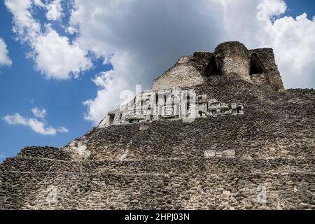 Schnitzereien der Maya-Pyramide 'El Castillo' an der archäologischen Stätte Xunantunich mit Wolkenlandschaft in der Nähe von San Ignacio, Belize Stockfoto