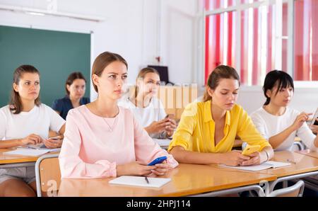 Die Schüler benutzen Smartphones während des Unterrichts Stockfoto