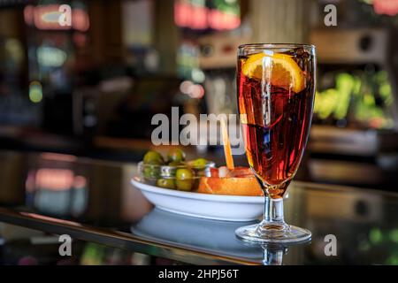 Traditionelle spanische Tapas aus grünen Oliven und ein Sandwich mit Schinken aus Jamon mit einem Cocktail an der Theke einer Bar in Madrid, Spanien Stockfoto