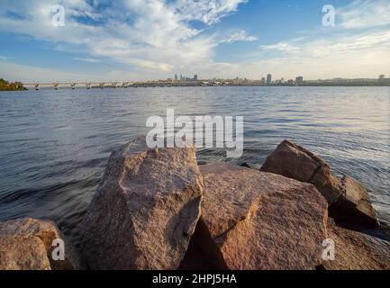 Dnepropetrovsk, Panorama der Stadt, Zentrum und zentrale Brücke am Ufer des Dnjepr, Granitsteine im Vordergrund Stockfoto