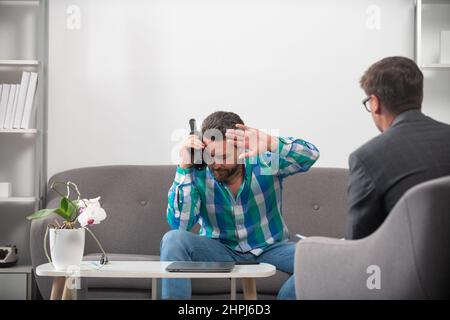 Verärgert Mann Alkoholiker sitzen bei Psychologen auf Psychotherapie-Sitzung, traurig depressiv süchtig betrunken Kerl mit Problem von Alkoholabhängigkeit Missbrauch Stockfoto