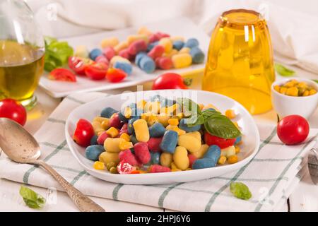 Farbige Gnocchi mit Gemüse und süßem Mais. Stockfoto