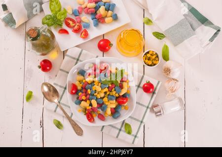Farbige Gnocchi mit Gemüse und süßem Mais. Stockfoto