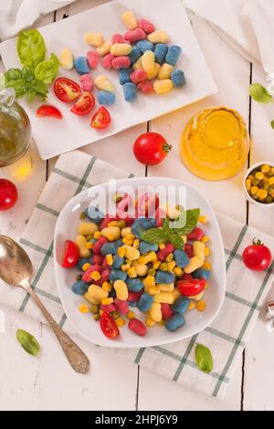 Farbige Gnocchi mit Gemüse und süßem Mais. Stockfoto